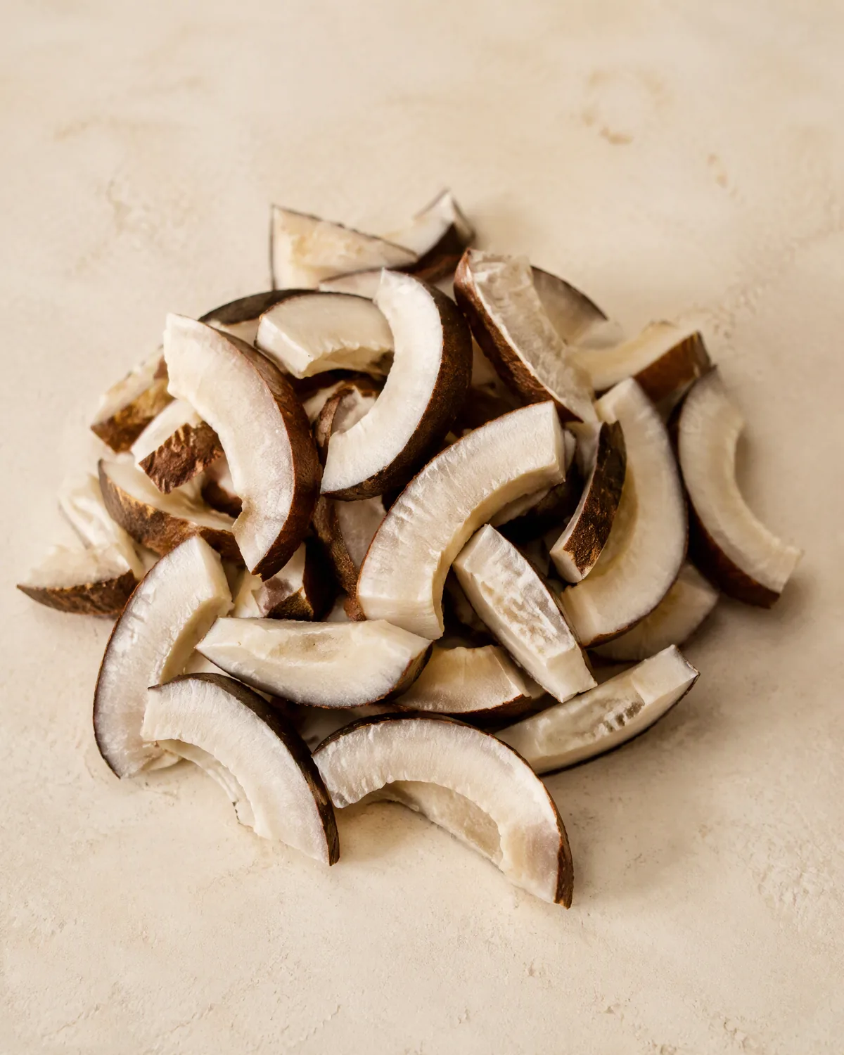 Illustrative image (placeholder): dried copra chunks on a cream surface